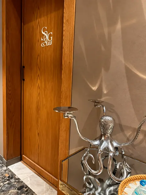 مدخل ساج سبا مع الشمعدان — SAG Spa entrance with sculptural candelabra